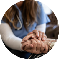 Eine medizinische Fachkraft hält die Hand einer älteren Pflegeperson.